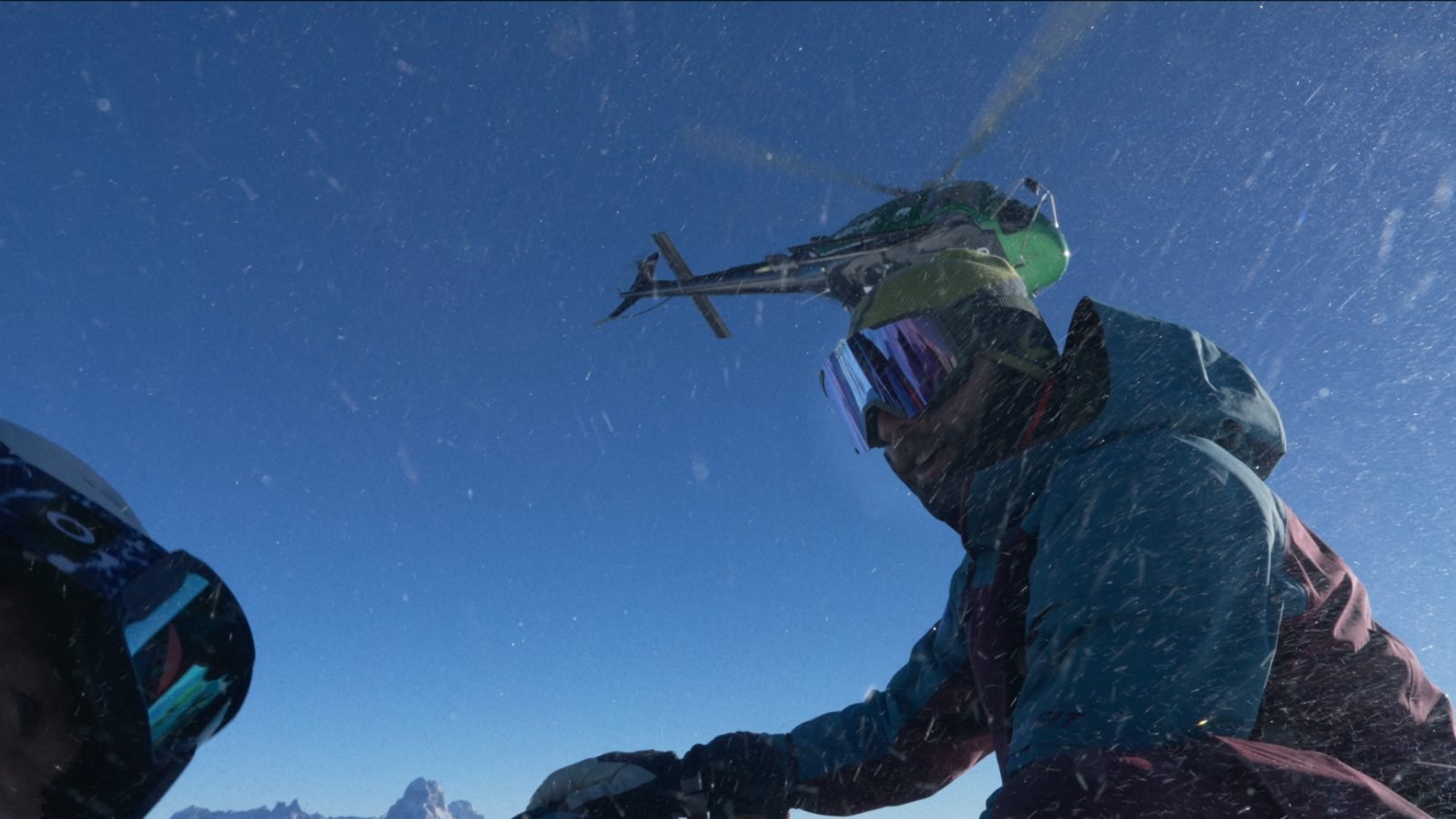 Helicopter lifting off after a drop — snow spray over freeriders in Georgia