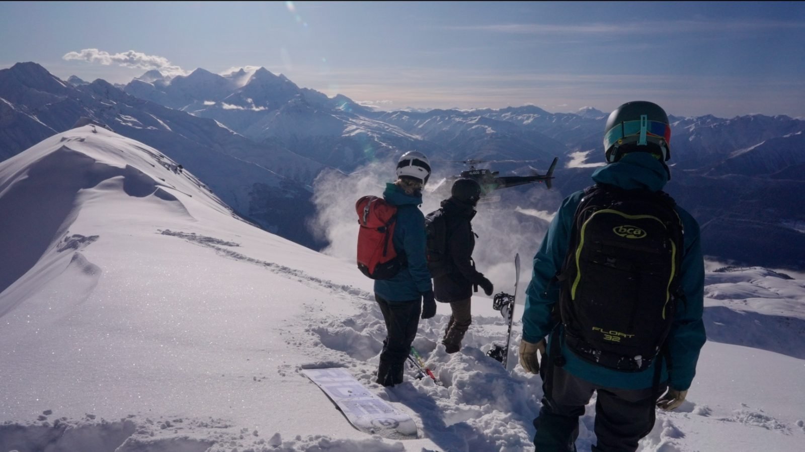 Heli-drop above Mestia — riders on the ridge as the helicopter comes in