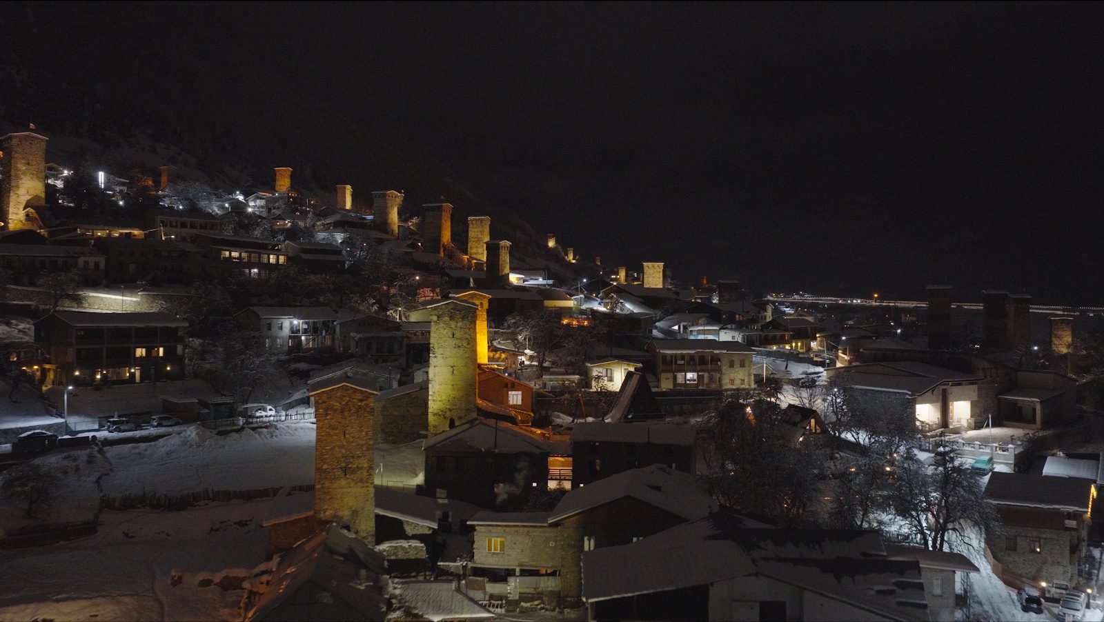 Illuminated towers and houses in Mestia at night