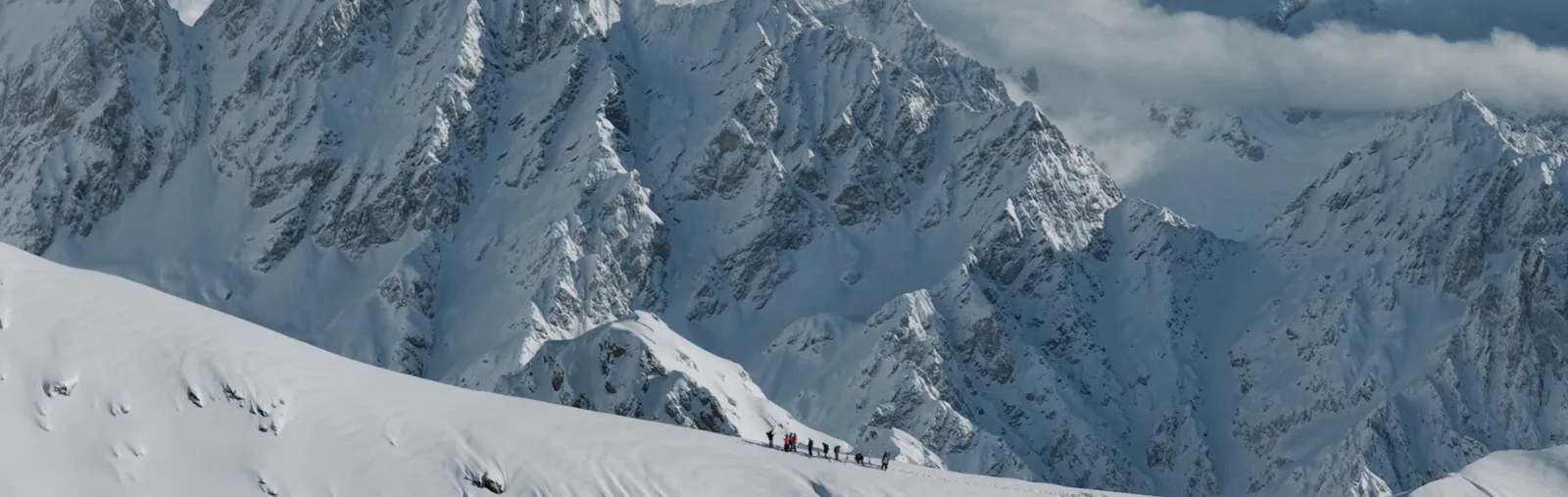 Ski touring group on a ridge beneath the Caucasus wall above Mestia, Upper Svaneti