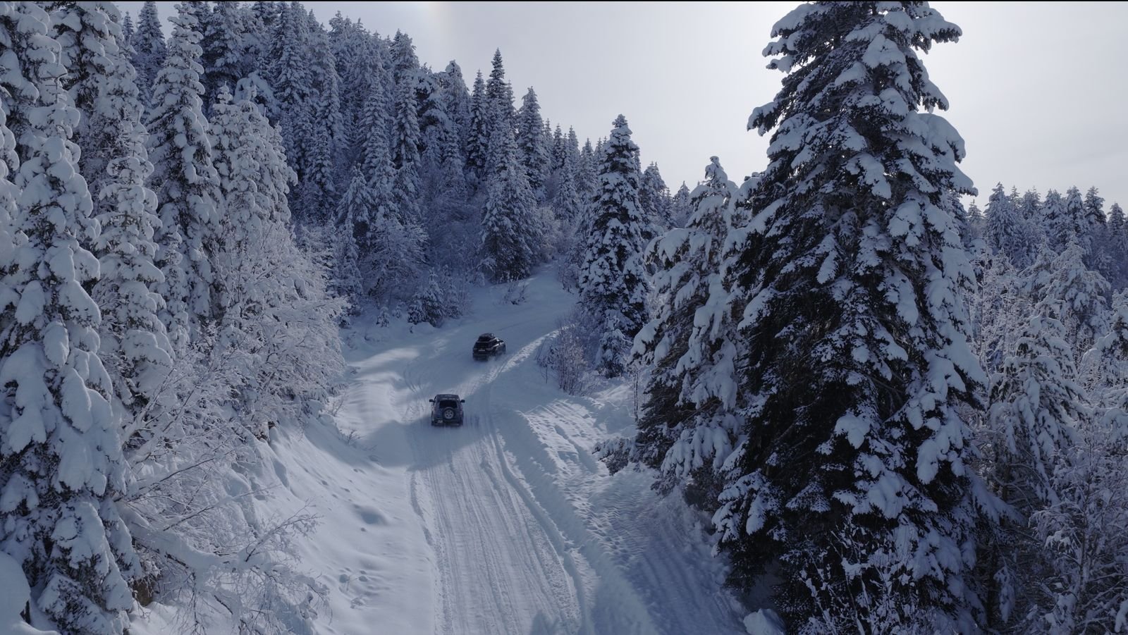 Vehicles on a snowy forest road to Mestia