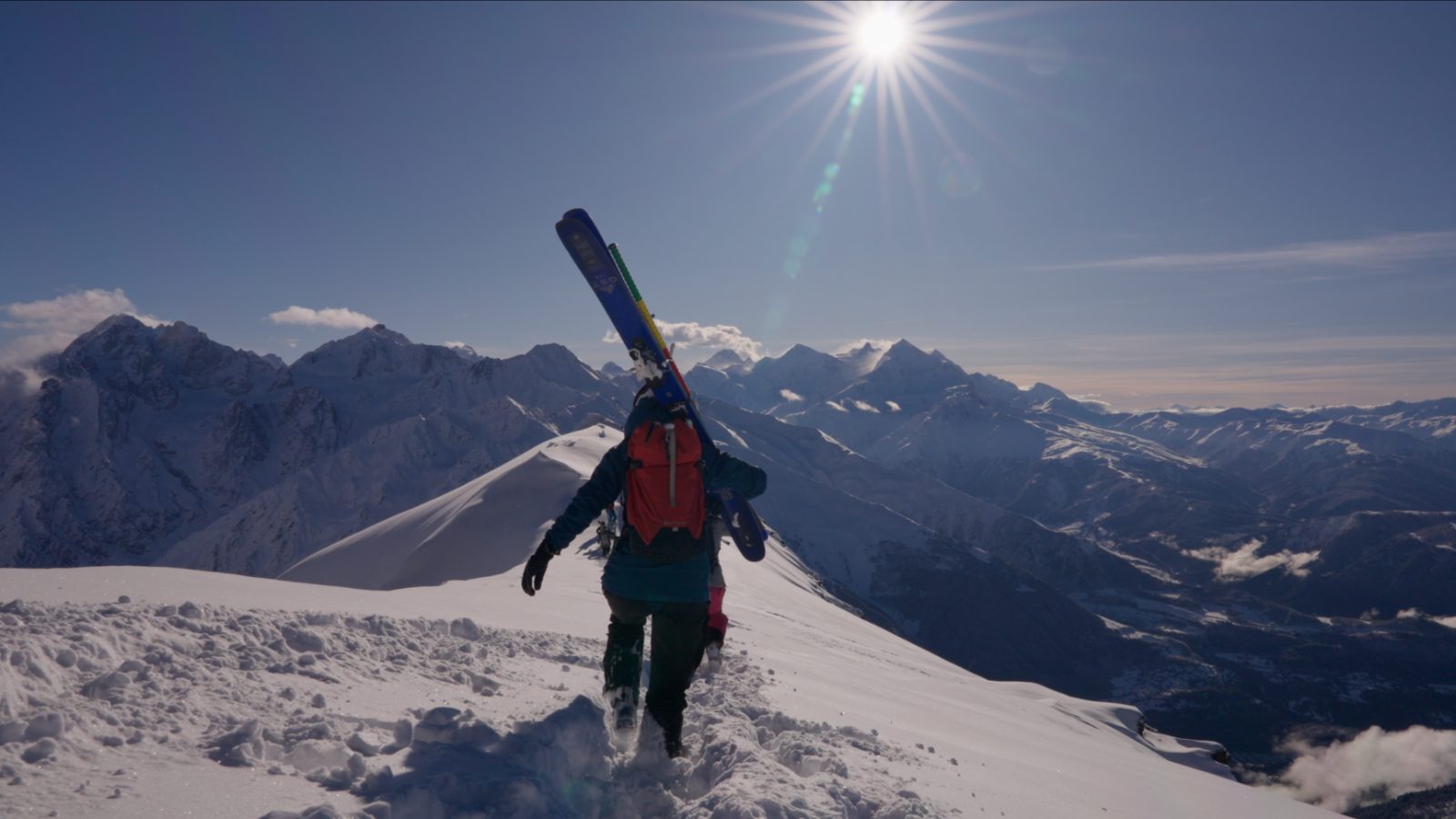 Hiking the ridge with skis on the shoulder — Hatsvali freeride with a guide