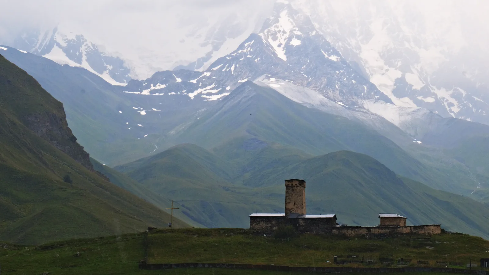 Lamaria church in Ushguli beneath mist-covered mountains.