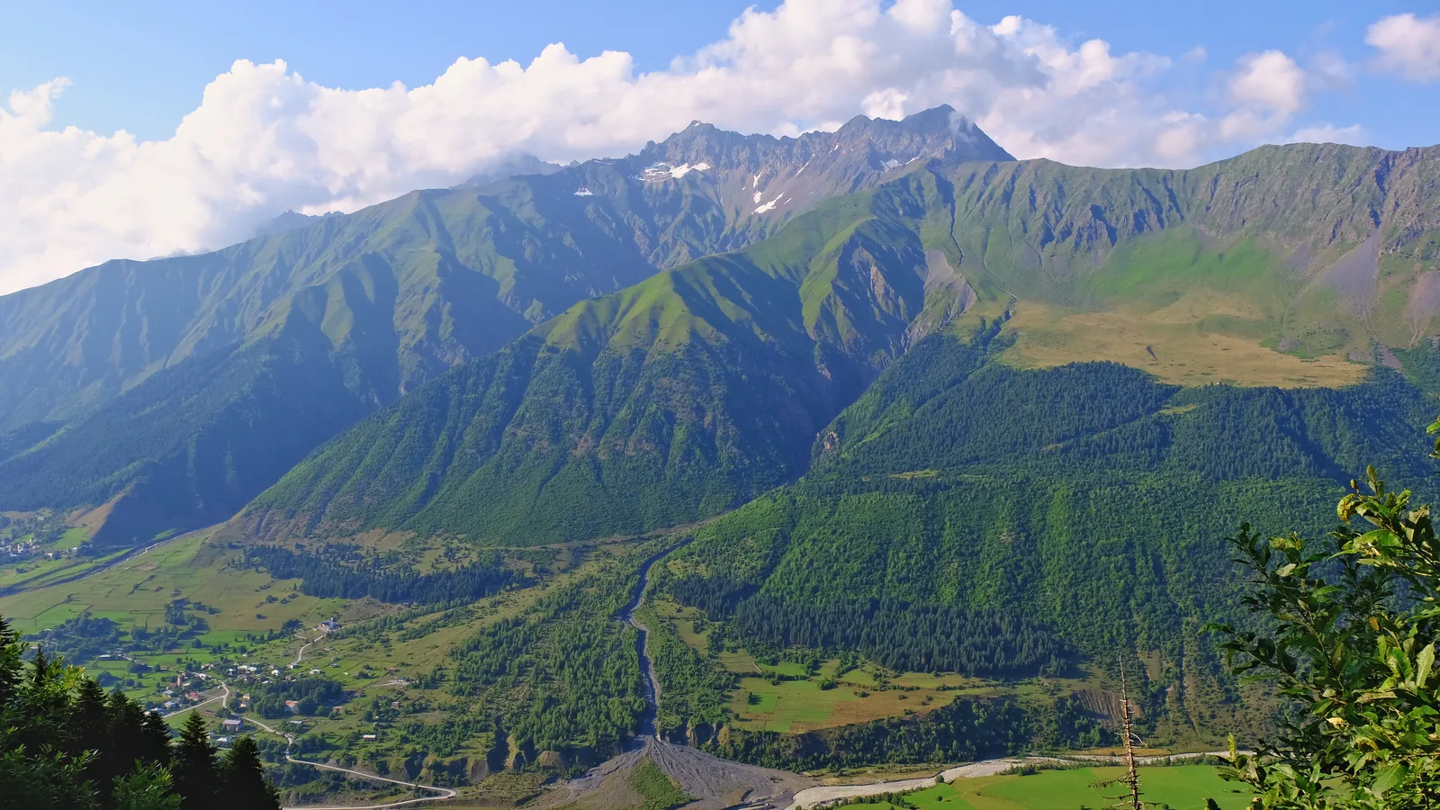 Green slopes and villages in the Mulakhi valley beneath the Caucasus.