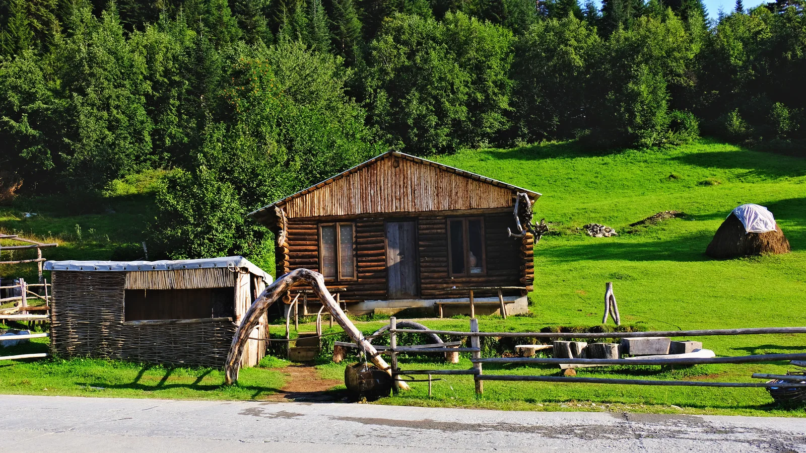 A wooden cabin, haystacks and a woven fence in the Mulakhi valley.