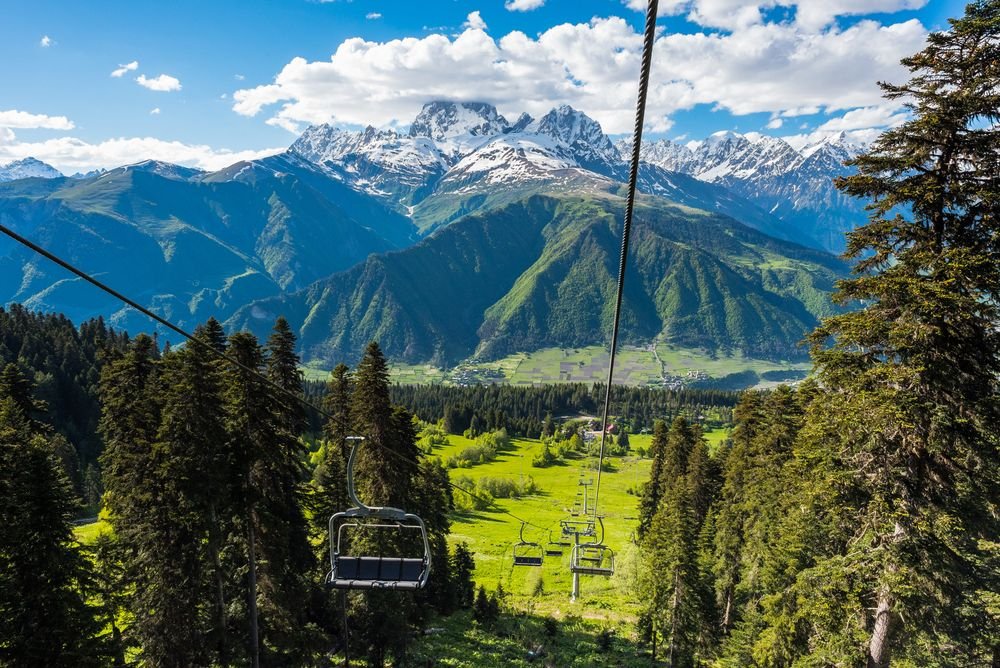 Hatsvali chairlift above summer meadows with Ushba behind