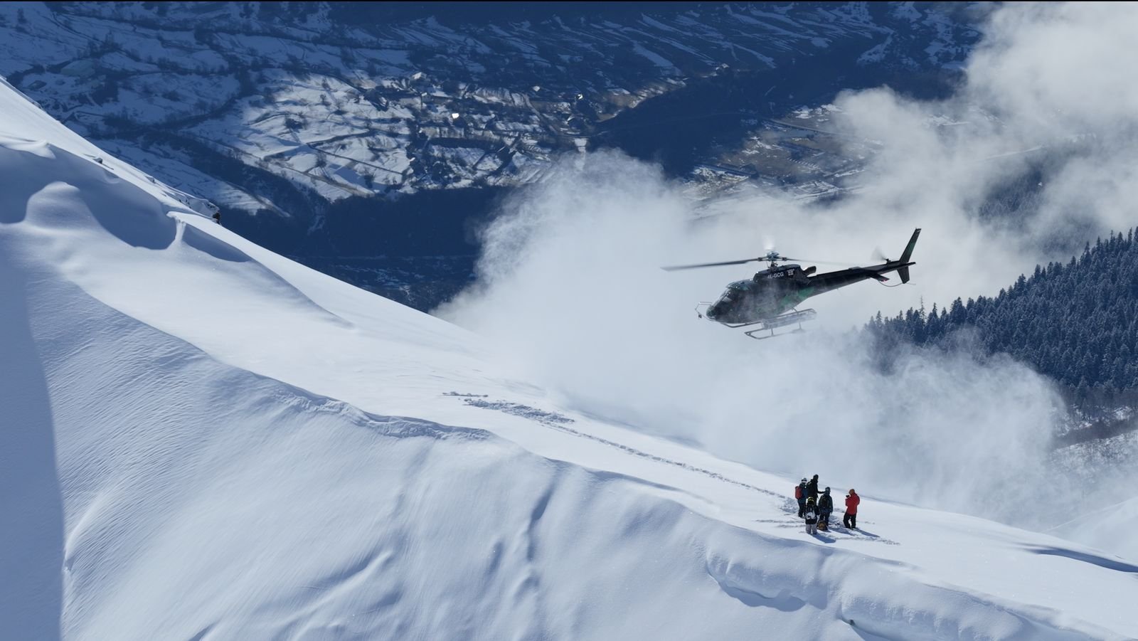 Helicopter dropping skiers on a Svaneti ridge