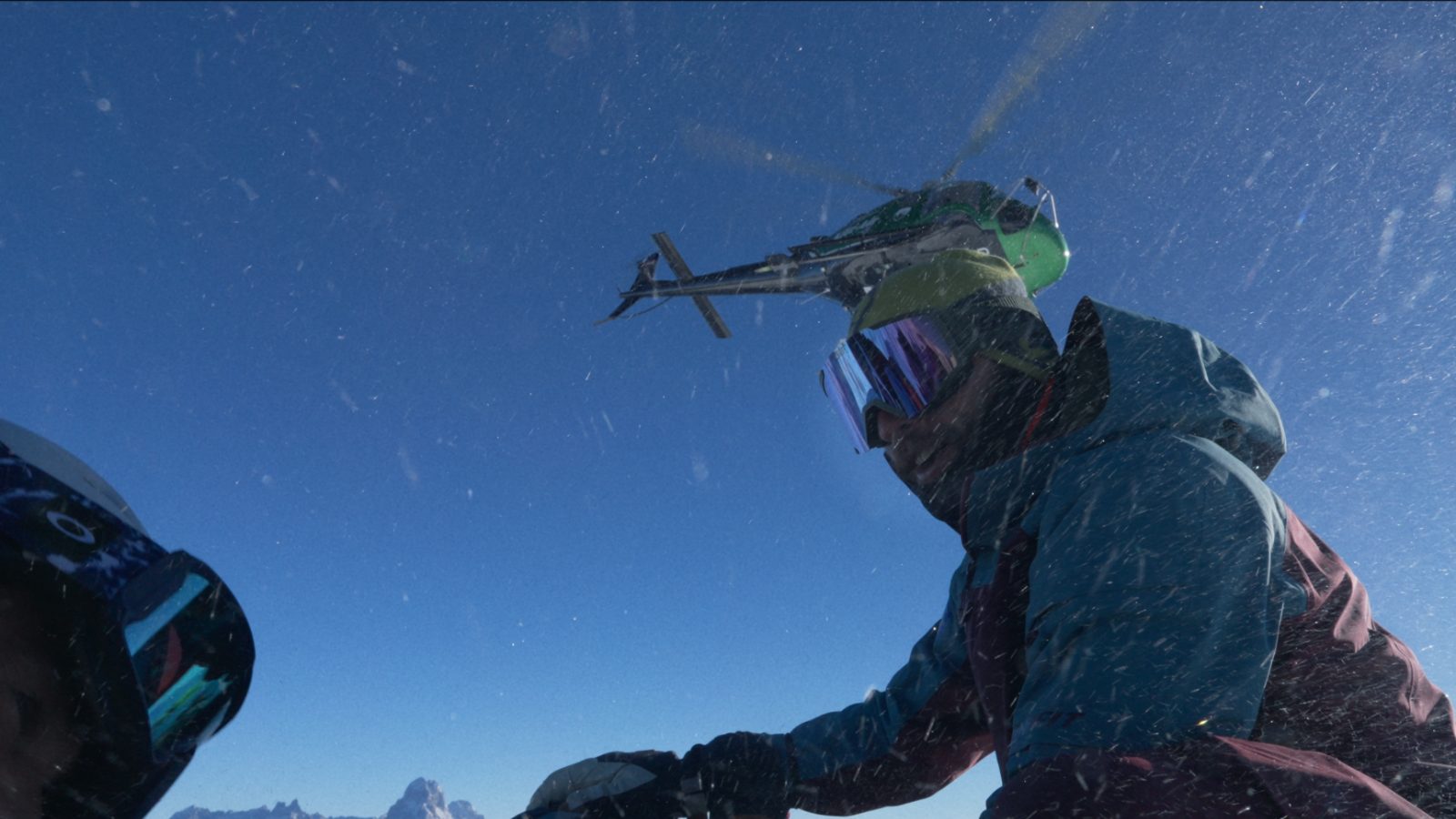 Helicopter lifting off after a drop — snow spray over freeriders in Georgia
