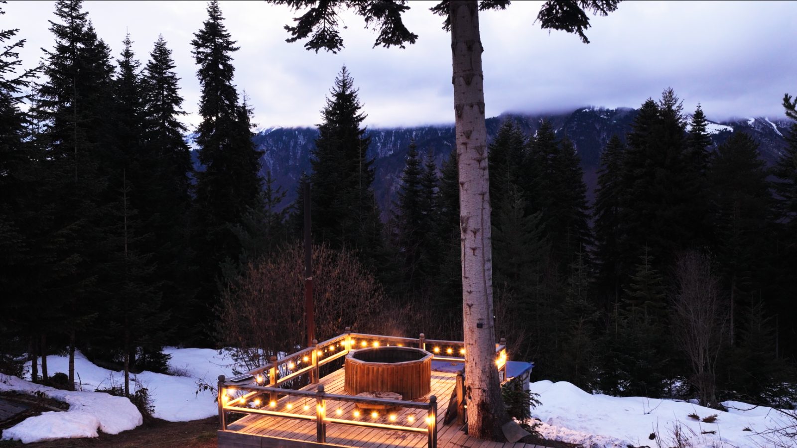 Hot tub on the forest deck at dusk — mountain hotel above Mestia, Svaneti