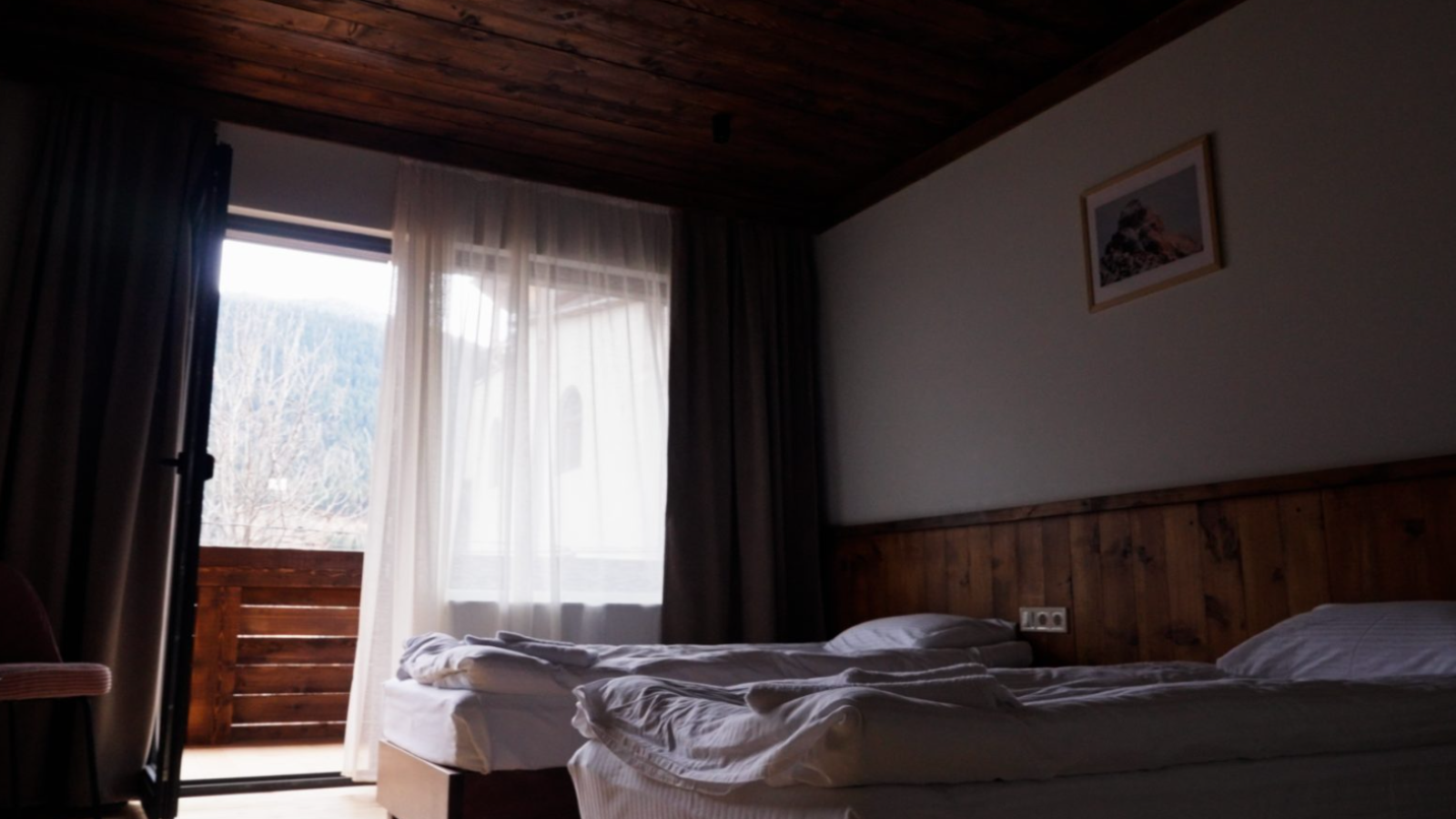Hotel room with wooden ceiling and balcony — mountain hotel in Mestia