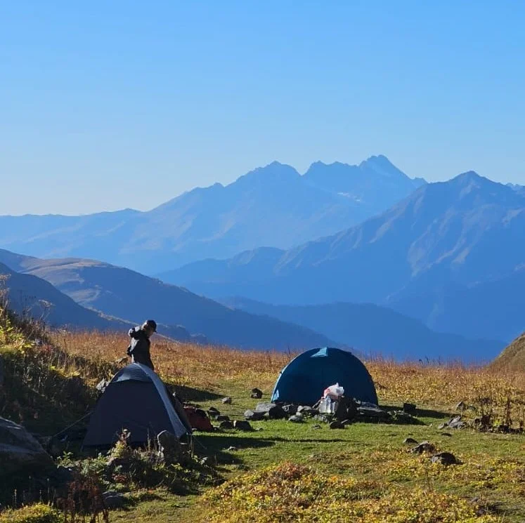 Tents on a grassy mountain plateau