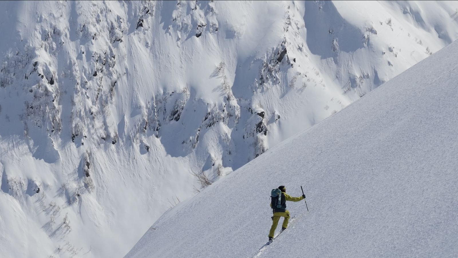 Solo ski tourer on a wide snowfield