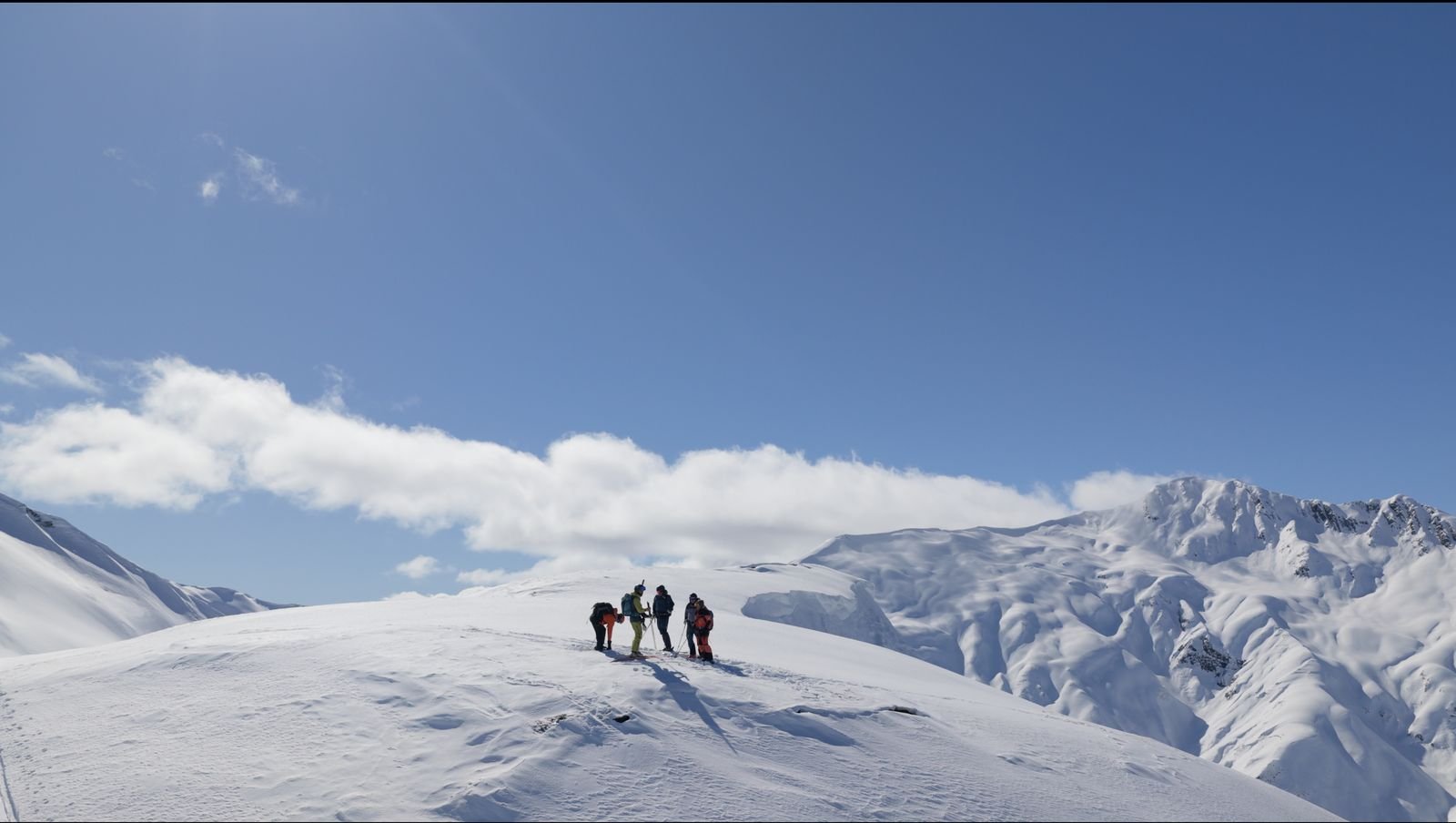 Group on a summit with clouds below