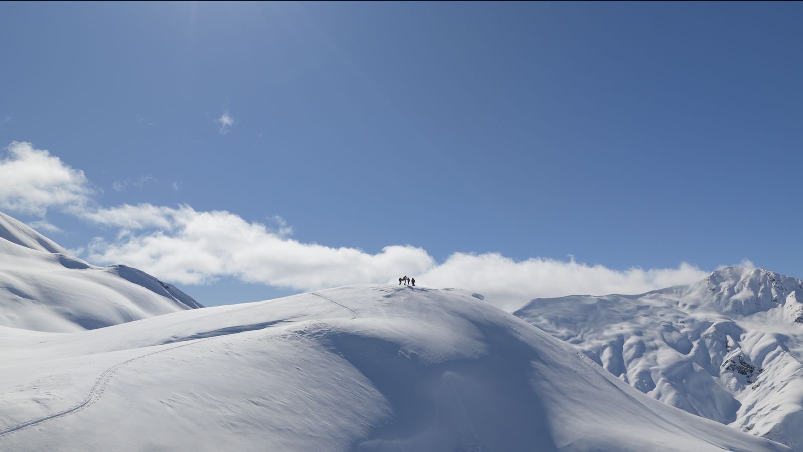 Two ski tourers on a summit above the clouds