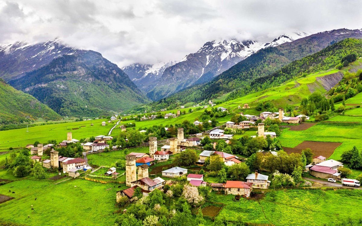 Svan village with towers in a green valley in spring