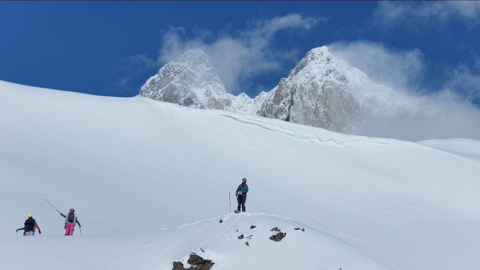 Ski tourers below the twin towers of Ushba